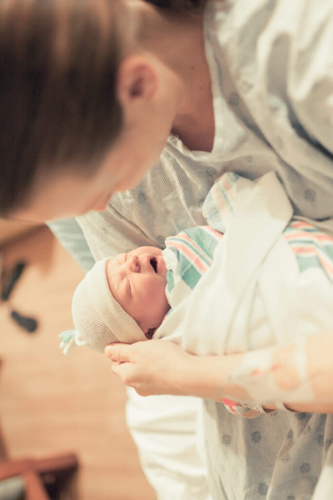Mother holding her newborn baby after labor in the hospital.