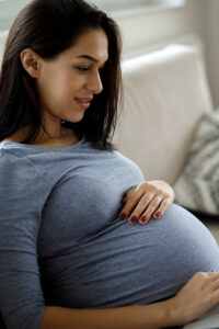 Happy pregnant woman holding her belly on Fabric Genomics